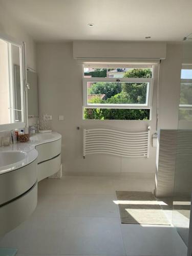 une salle de bain blanche avec un lavabo et une fenêtre dans l'établissement Grande villa californienne calme près de la mer, au Golfe-Juan