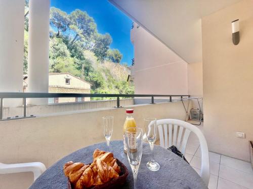 - une table avec des verres et une bouteille de vin sur le balcon dans l'établissement One Bedroom Flat Near Monaco, à Beausoleil