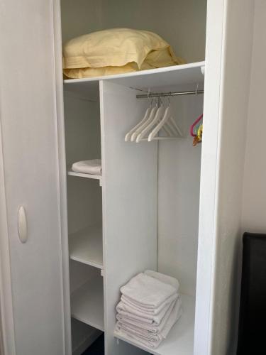 - un placard blanc avec des serviettes blanches dans l'établissement Chez Bonamy, à Pornichet