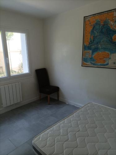 - une chambre avec un lit, une chaise et une carte dans l'établissement plain pied proche de la plage, à Saint-Georges-de-Didonne