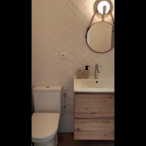 une salle de bain avec toilettes, lavabo et miroir dans l'établissement Maison cosy Paris La Défense, à Nanterre