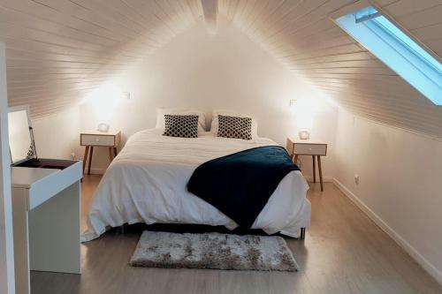 une chambre avec un grand lit dans une pièce blanche dans l'établissement Maison cosy Paris La Défense, à Nanterre