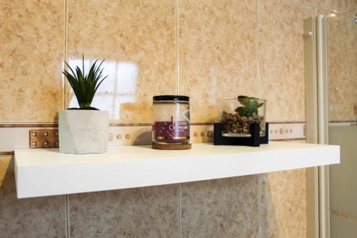 a white shelf in a bathroom with a plant at House 37North in Mosteiros