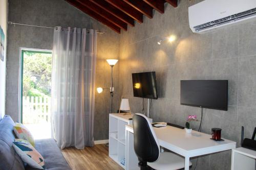 a room with a desk and a tv on a wall at House 37North in Mosteiros