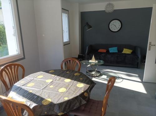 ein Wohnzimmer mit Tisch und Couch in der Unterkunft plain pied proche de la plage in Saint-Georges-de-Didonne