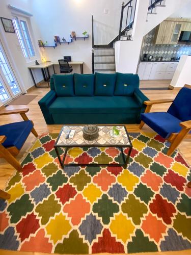 a living room with a blue couch and a colorful rug at Comfort & Cozy, Villa in Orchha