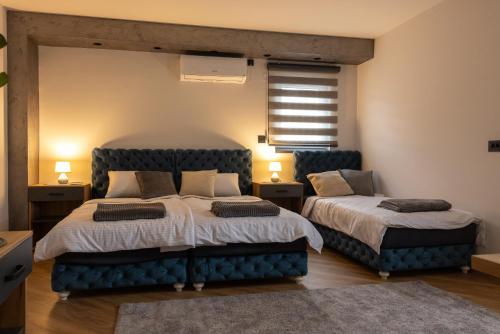a bedroom with two beds and two chairs at Apartmani Skadarlija Valjevo in Valjevo