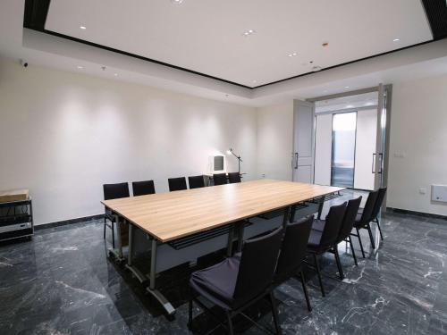 a conference room with a wooden table and chairs at Novotel Nantong Center in Nantong