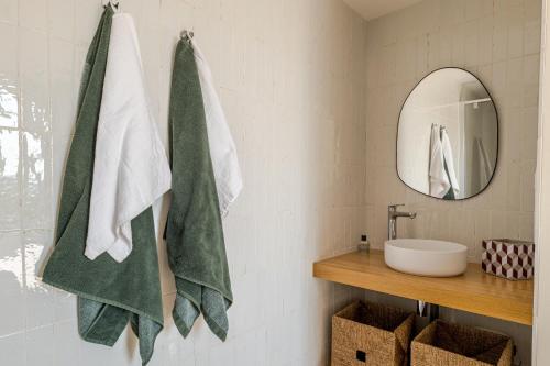une salle de bain avec des serviettes vertes et blanches et un lavabo dans l'établissement Charmante maison de famille au calme, 5 chambres, à Les Salles