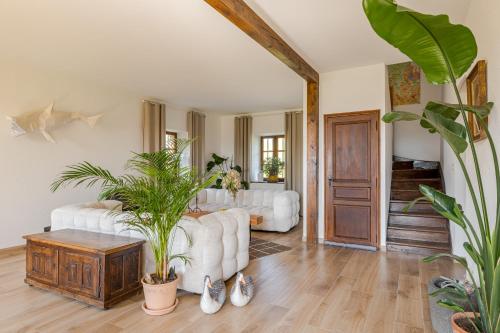 un salon avec des meubles blancs et des plantes dans l'établissement Charmante maison de famille au calme, 5 chambres, à Les Salles