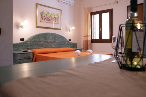 a bedroom with an orange bed and a table at Residence con piscina a Sos Alinos in Cala Liberotto