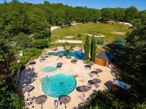 une vue aérienne d'une piscine avec des parasols et des gens dans l'établissement Chalet 3 étoiles - Piscine - efchcg, à Saint-Cirq-Lapopie