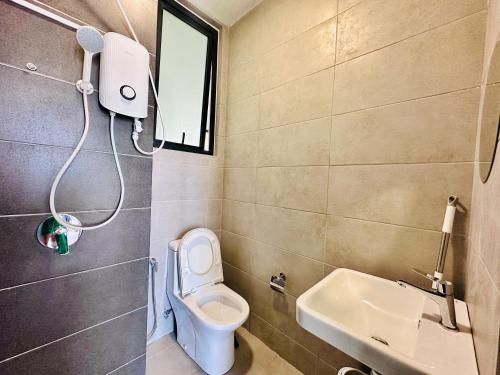 a bathroom with a toilet and a sink at Familystay Home 3BR-10PAX in Gua Sai