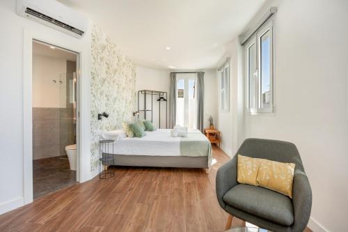 a bedroom with a bed and a chair at Casa Milano 3 in Jerez de la Frontera