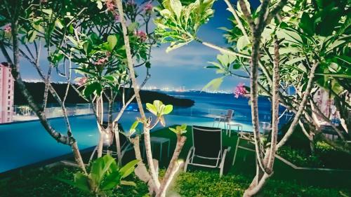 a view from the garden of the pool through the trees at Familystay Home 3BR-10PAX in Gua Sai