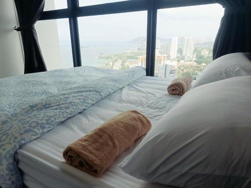 a bedroom with a bed with pillows and a large window at Familystay Home 3BR-10PAX in Gua Sai