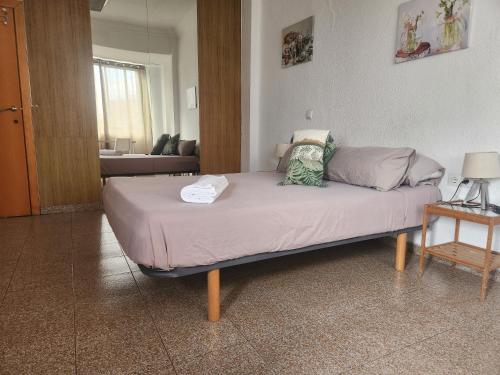 a large bed in a room with a couch at eXperience Rooms Valencia in Valencia