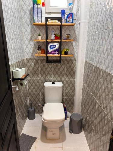 スキクダにあるAppartement F3 Bouzaaroura Skikdaの小さなバスルーム(トイレ、棚付)