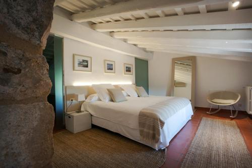 um quarto com uma cama branca e uma mesa em Mas Falgarona Hotel Boutique & SPA em Avinyonet de Puigventós