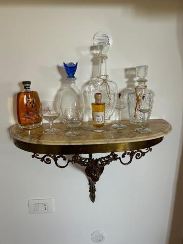 a shelf with glasses and bottles on a wall at Relais La Villa in Lucera
