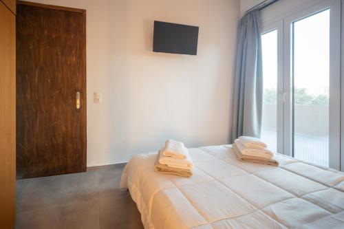 a bedroom with a bed with towels on top of it at Luxury apartment with rooftop pool in Meronas in Méronas