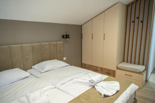 a bedroom with a large white bed with towels on it at Hotel CENTRAL in Prilep