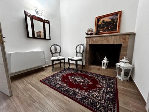 a living room with two chairs and a fireplace at Relais La Villa in Lucera