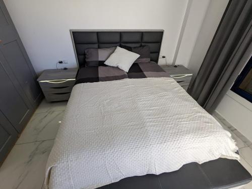 ein Schlafzimmer mit einem großen Bett mit zwei Nachttischen in der Unterkunft Torrevieja - La Mata Beach First Line New Apartments 2024r in La Mata