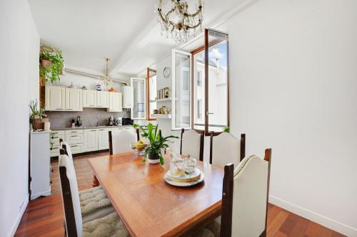 une cuisine et une salle à manger avec une table et des chaises en bois dans l'établissement Chez Maguy, à Paris