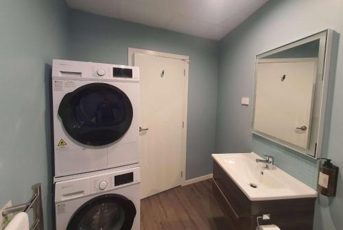 a bathroom with a washing machine and a sink at La Quinta by Wyndham Parnell Auckland in Auckland