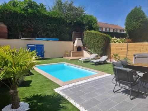 a backyard with a swimming pool and a grill at Spassionnement pool in Jouy-le-Moutier