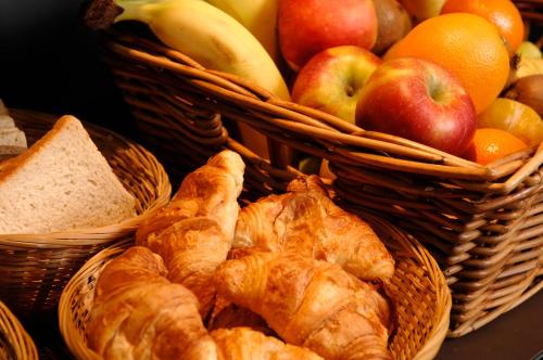 two baskets filled with bread and fruit on a table at IntercityHotel Dresden in Dresden