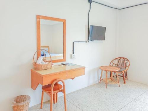 a dressing room with a mirror and a table and chairs at Bangsaphan Resort in Bang Saphan
