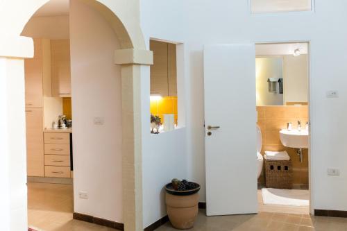 bagno con pareti bianche, lavandino e specchio di Casa Vacanze Le Esperidi a Matera