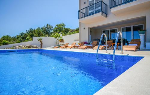 una piscina di fronte a una villa di Gorgeous Home In Veli Rat With Wifi a Veli Rat