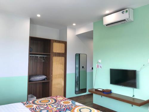 a bedroom with a bed and a flat screen tv at Xenia House Cao Bang City in Cao Bằng