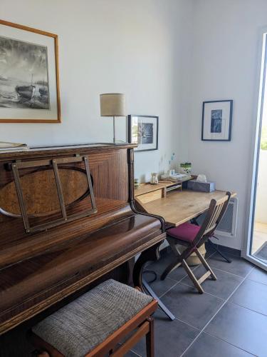 un piano dans une pièce avec un bureau et une table dans l'établissement Chambre vue mer, à Marseille