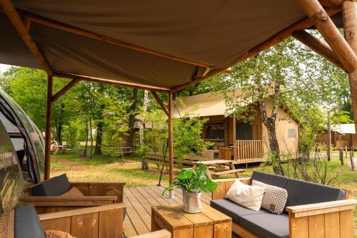 a patio with a tent and chairs and a table at Slow Living bij Mölke X Glamping in Zuna
