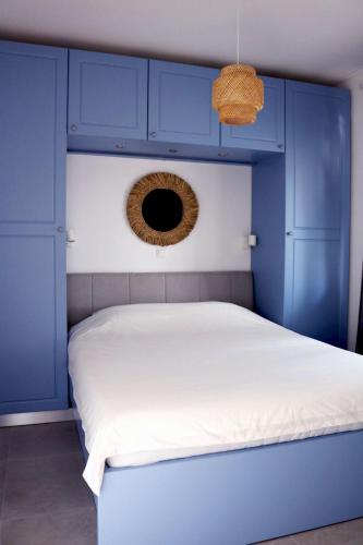 a bedroom with blue cabinets and a white bed at Apartment Lavander in Novalja