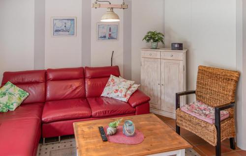 a living room with a red couch and a table at Lovely Home In Nordstrand Nordstrand in Kiefhuck