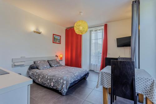 une chambre avec un lit et un rideau rouge dans l'établissement Le Granier - Studio climatisé vue montagne, à Chambéry