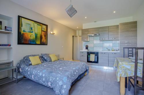 une chambre avec un grand lit et une cuisine dans l'établissement Le Nivolet - Studio vue montagne, à Chambéry