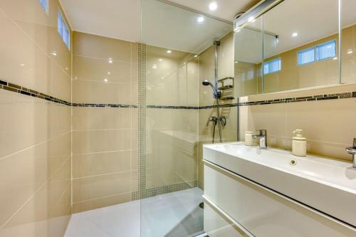 une salle de bain avec une douche, un lavabo et un miroir dans l'établissement Luxe Parisien au cœur du Marais, à Paris