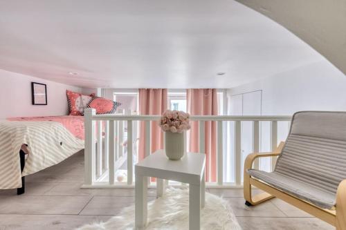 une chambre avec un lit et un vase de fleurs sur une table dans l'établissement Luxe Parisien au cœur du Marais, à Paris