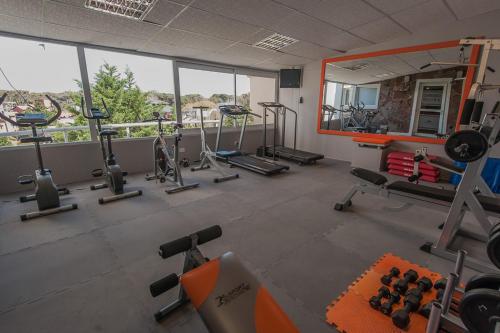 a gym with several tread machines and a mirror at Marcin Hotel in Carilo