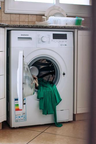 a washing machine with a green cloth inside of it at Artemis Cynthia Complex in Paphos City