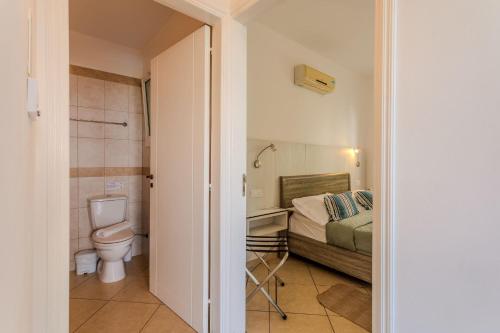 a small bathroom with a bed and a toilet at Artemis Cynthia Complex in Paphos City