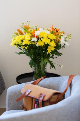 a bouquet of flowers in a vase with a purse at Artemis Cynthia Complex in Paphos City