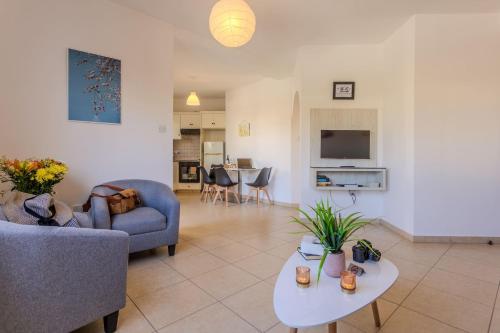 a living room with a couch and a table at Artemis Cynthia Complex in Paphos City