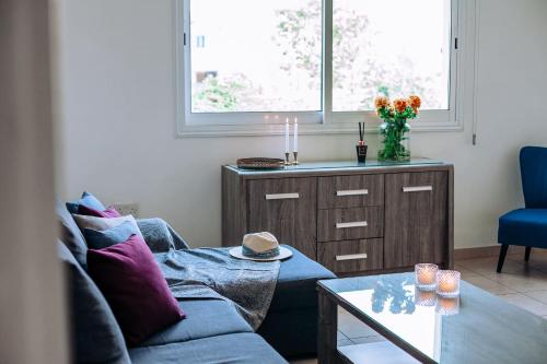 a living room with a couch and a table at Artemis Cynthia Complex in Paphos City